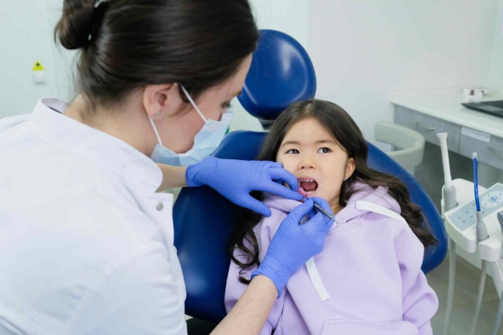 Child receiving dental check-up from a dentist in a modern clinic, emphasizing expert dental care and smile enhancement.